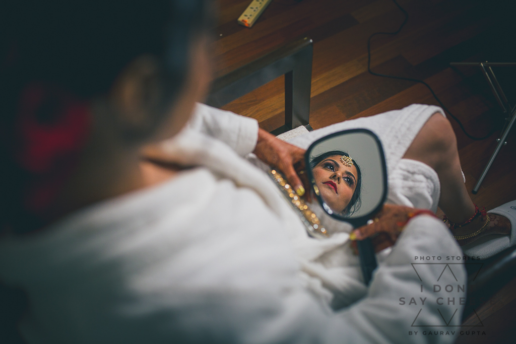 Bride getting ready looking in the hand mirror