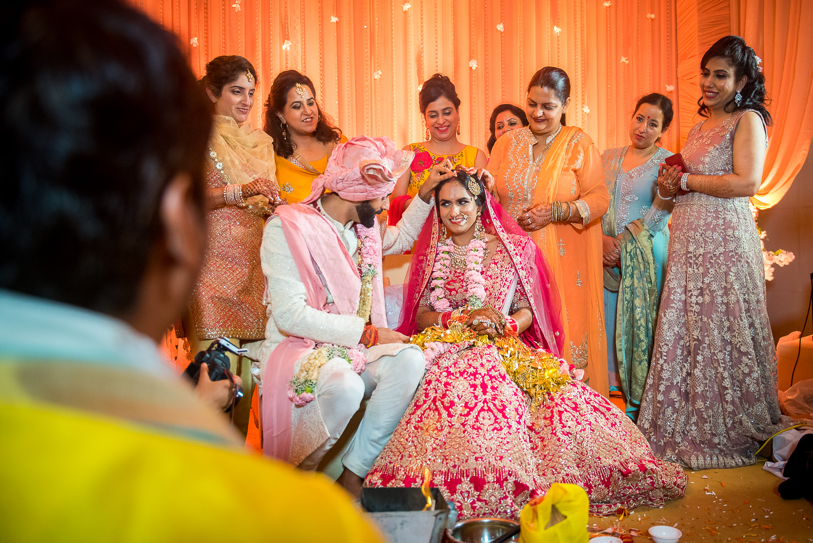 groom applies sindoor on the bride's forehead at wedding