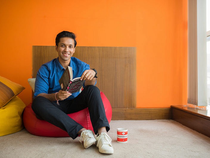 Durjoy Datta on a bean bag reading his book