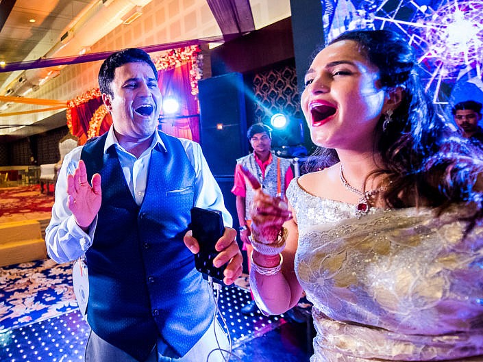 couple dancing with open mouths at indian wedding