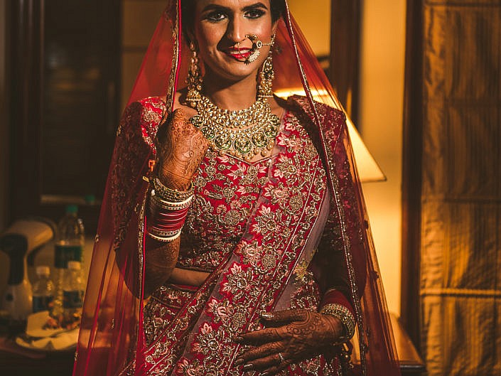 bride in a red lehenga with kundan jewels