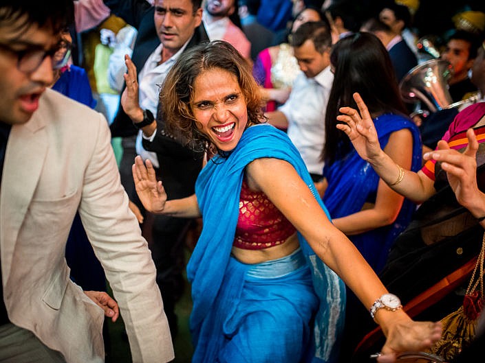 girl in blue sari dancing at indian wedding in delhi