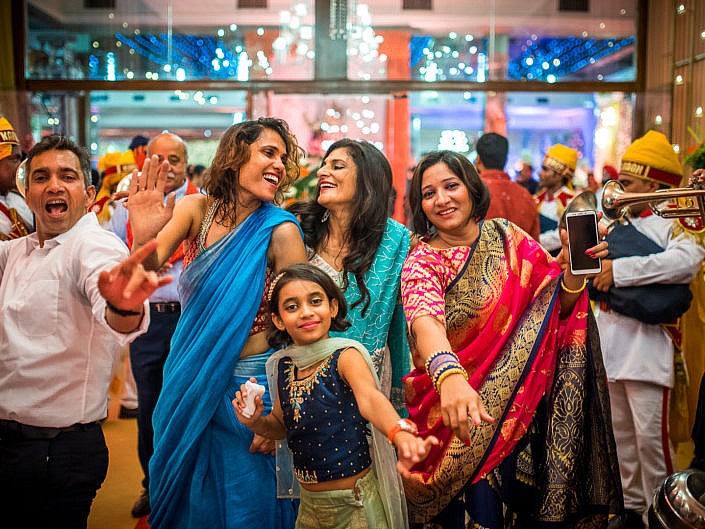 beautiful ladies dancing at the baraat at an indian wedding