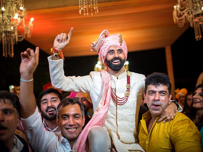 an excited groom entering the venue with his friends at indian wedding