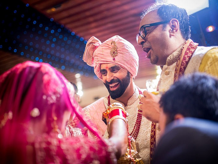 smiling groom as he takes the bride's hand