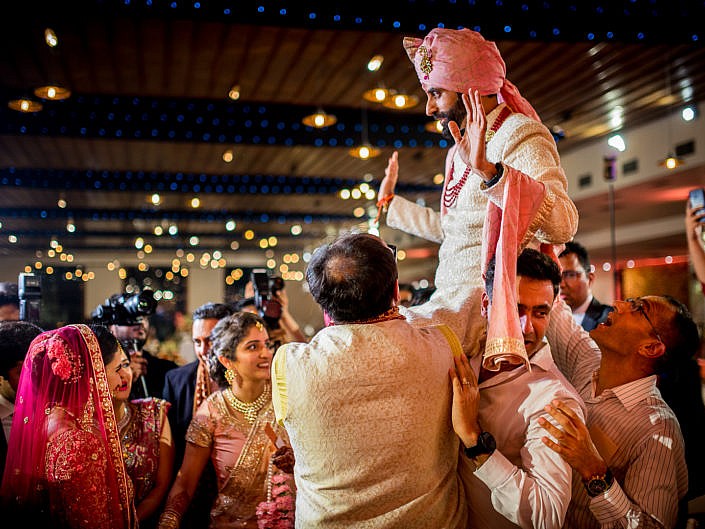 groom being lifted during varmaala ceremony