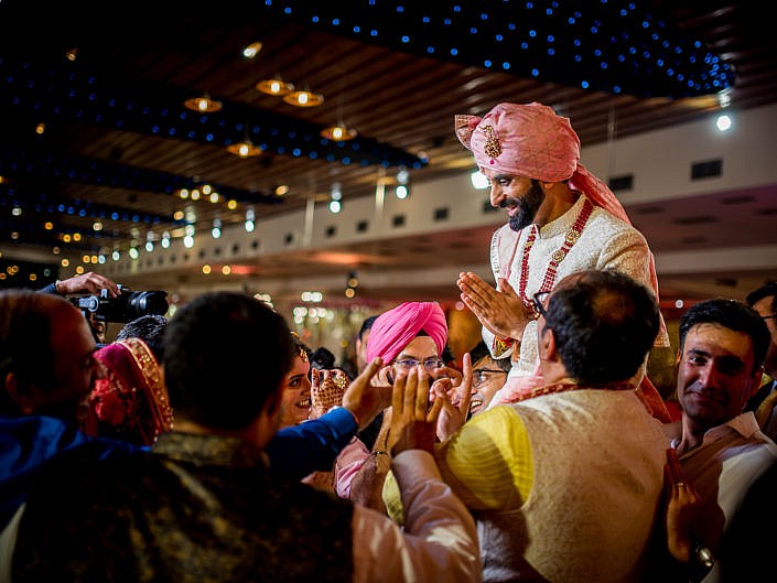 groom being lifted during varmaala ceremony