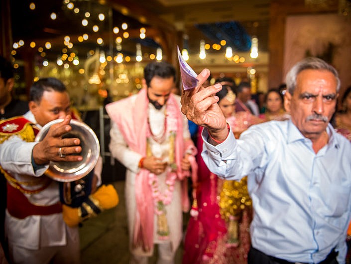 man paying the band money at indian wedding