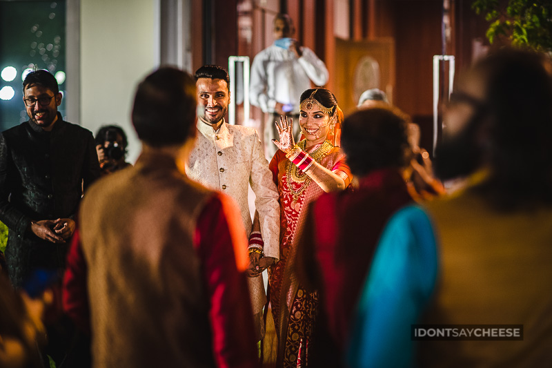 indian wedding couple waving to friends and family